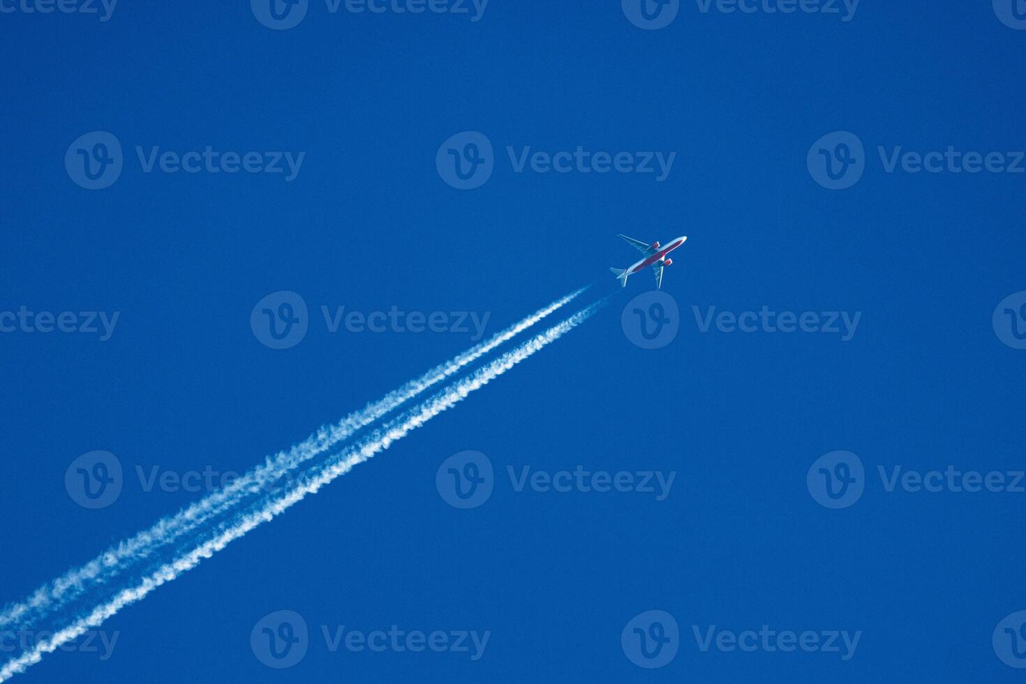 Sky Symphony An Airplane Dances Through the Azure Canvas, Leaving Behind a Whisper of Contrails. photo