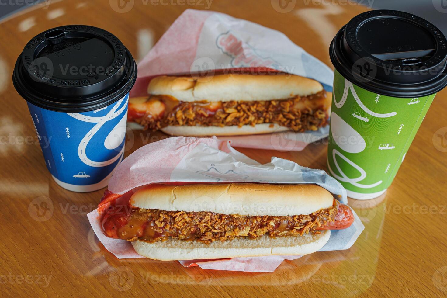 Morning Comfort A Pair of Hot Dogs and Coffee Cups Awaiting Enjoyment, Evoking Warmth and Simple Pleasures. photo