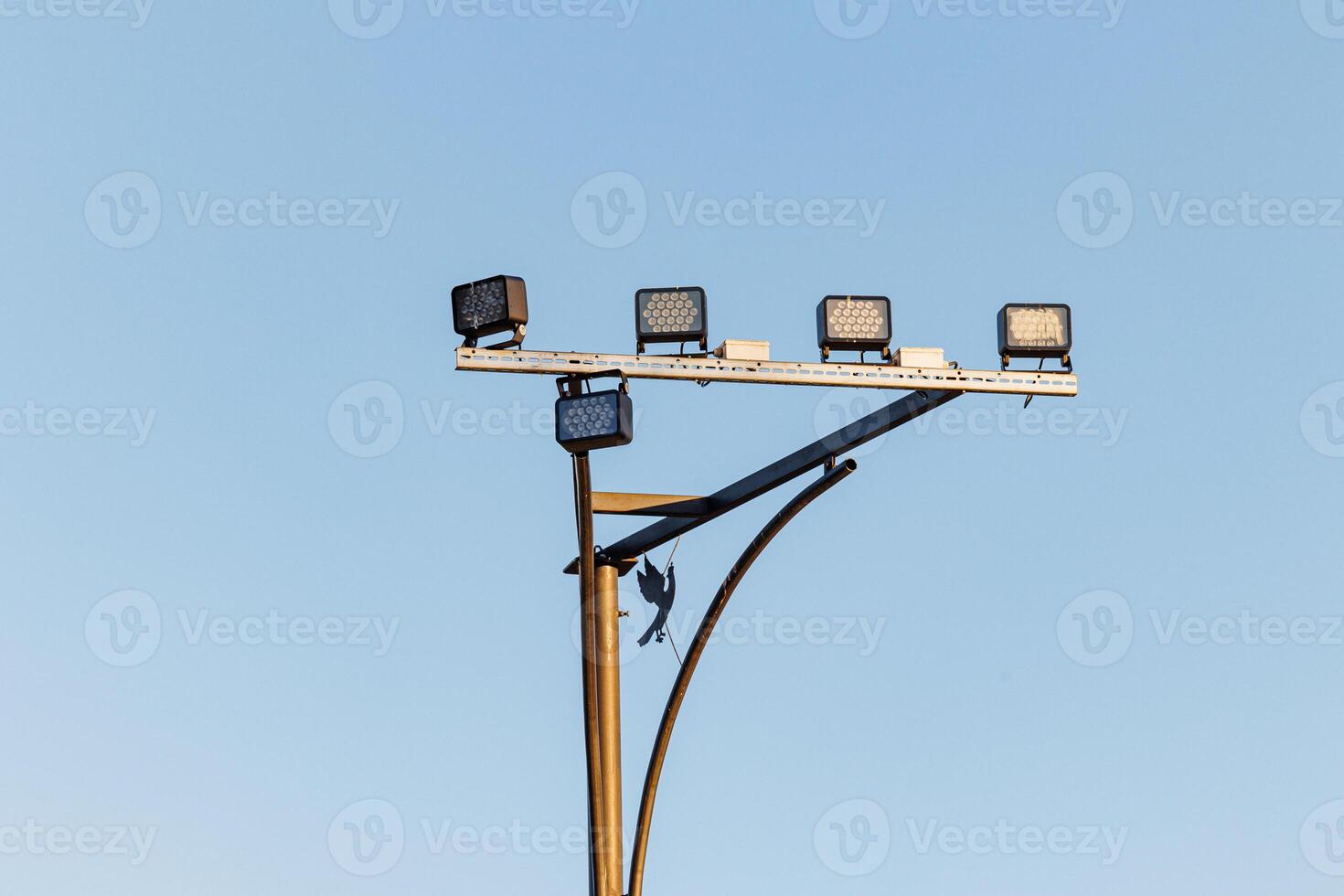 Illuminated Nexus A Striking Lamp Post Adorned with Radiant Floodlights, Casting Eloquent Shadows on the Urban Canvas. photo