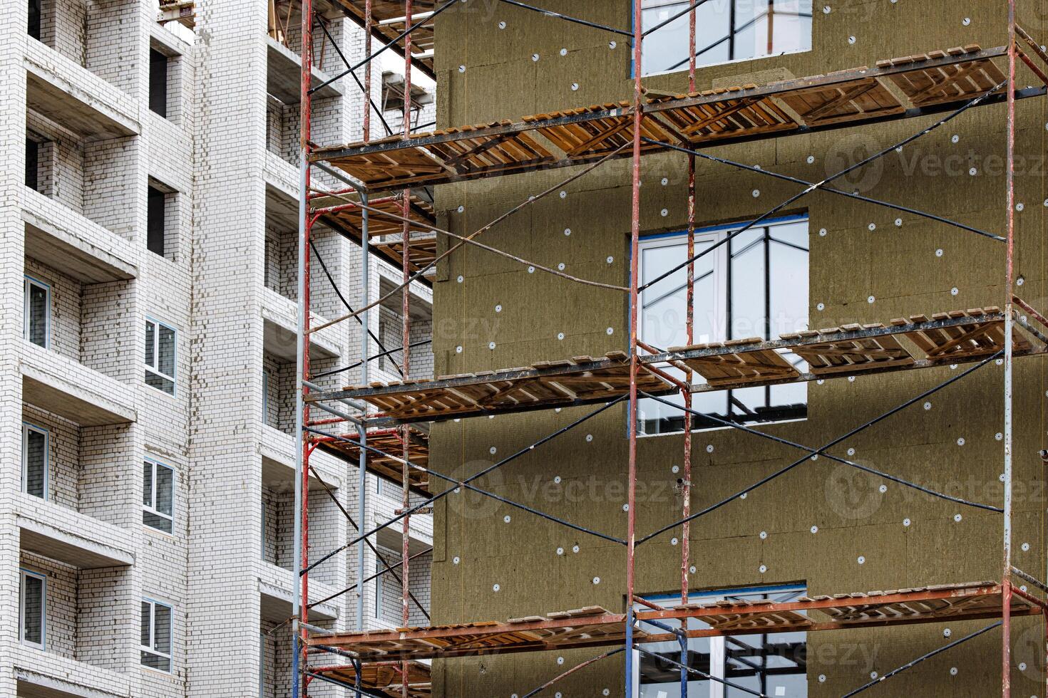 Steel beams rise against a twilight sky, wrapped in a web of scaffolding. The heartbeat of progress pulses through the skeletal structure, promising a future yet to unfold. photo