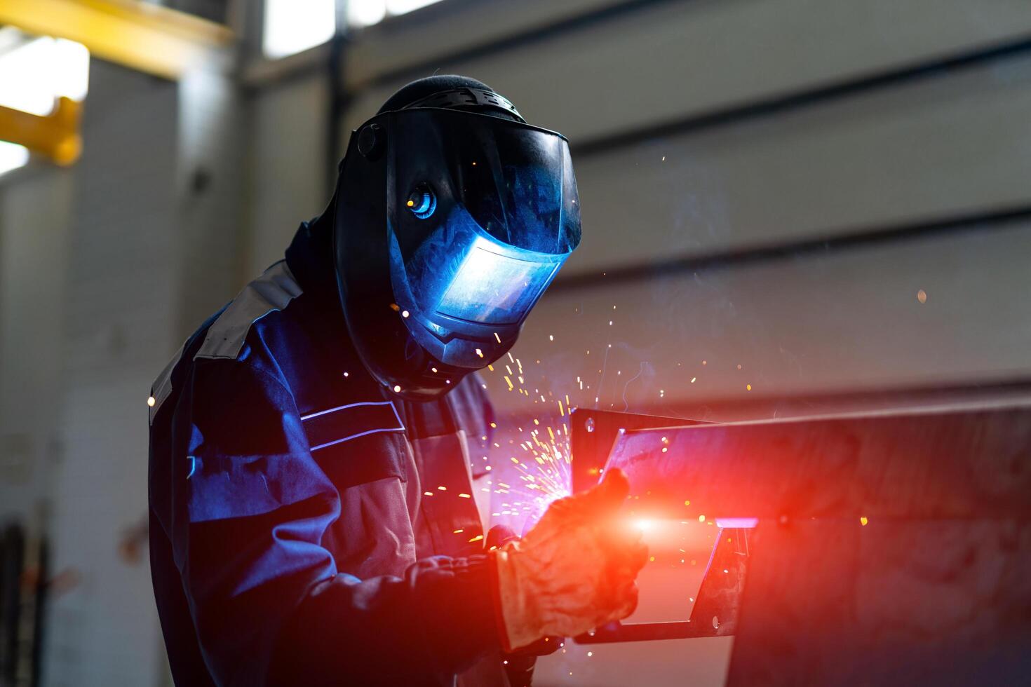 Metal working man welding in mask. Handymen perfoming welding at workplace. photo
