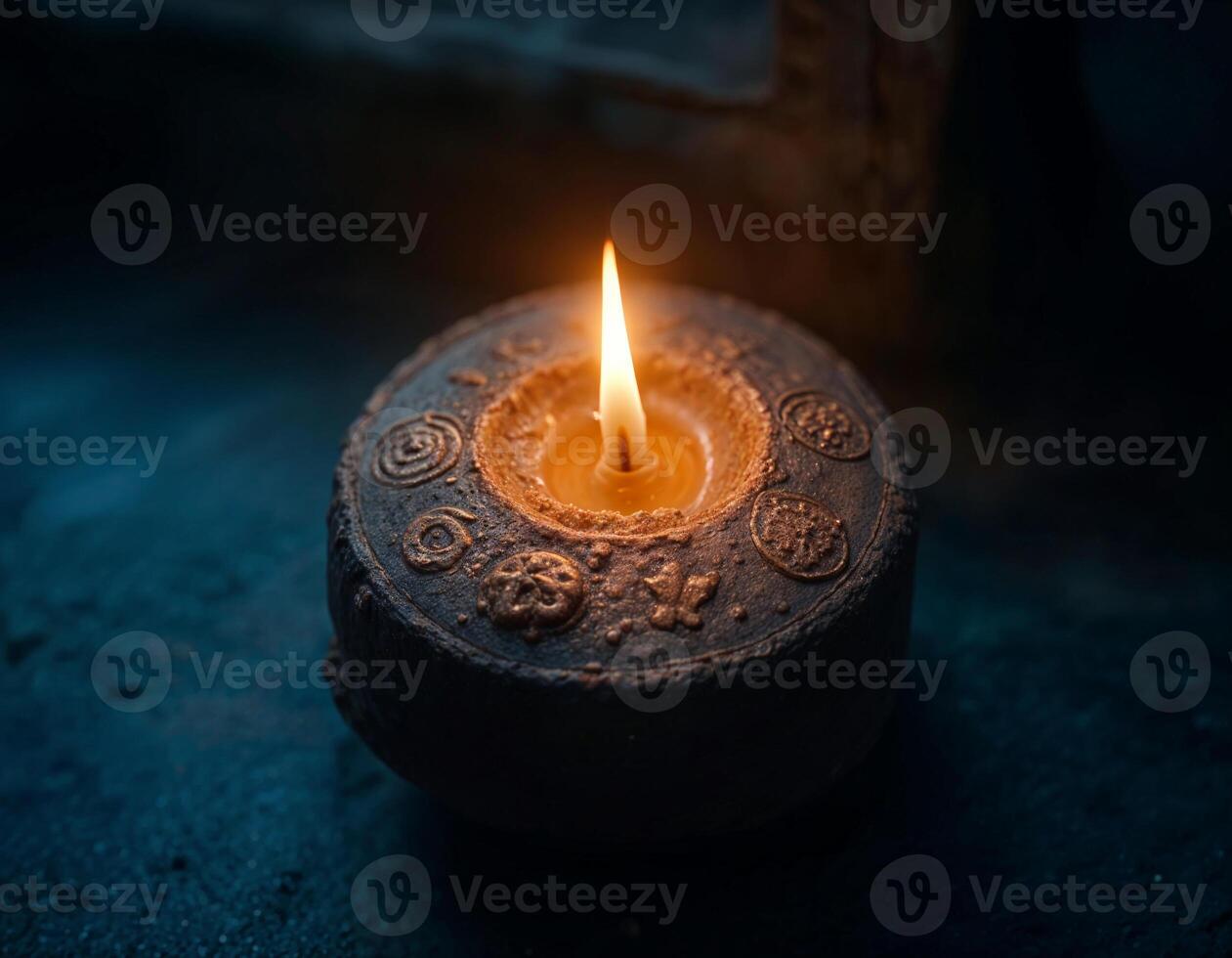 a candle is lighten up on a dark background surrounded by various religious symbols on it photo