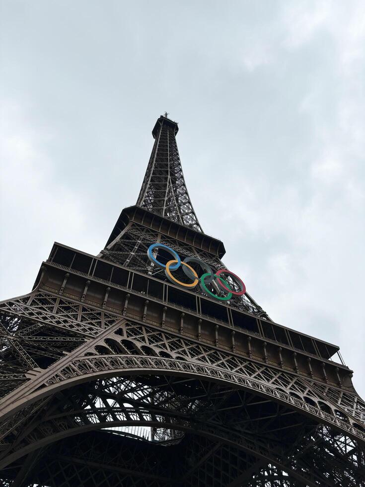 Paris, France - June 19, 2024 Eiffel Tower with Olympic rings against a cloudy sky photo