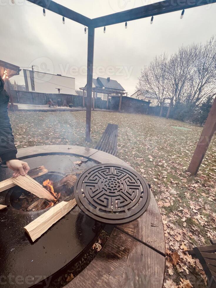 Outdoor fire pit with wooden logs in a cozy backyard setting photo