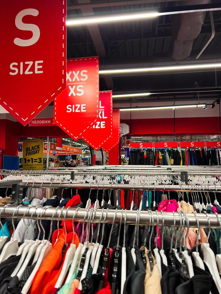 Kyiv, Ukraine - November 20, 2024 Colorful clothing racks in retail fashion store with size signs photo