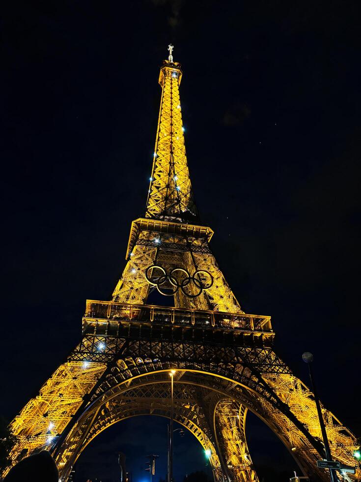 Paris, France - June 19, 2024 Illuminated Eiffel Tower at night with Olympic rings displayed photo