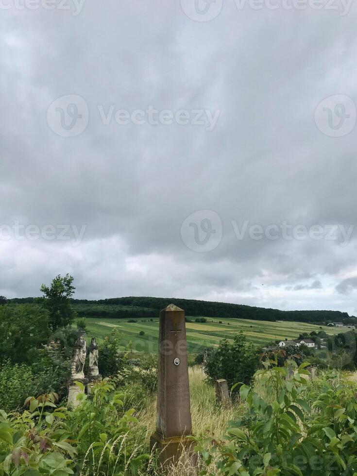 Scenic rural landscape with historical stone monument and cloudy sky photo