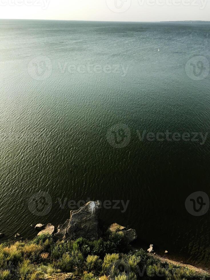 Tranquil lakeside view with rocky shoreline and expansive water photo