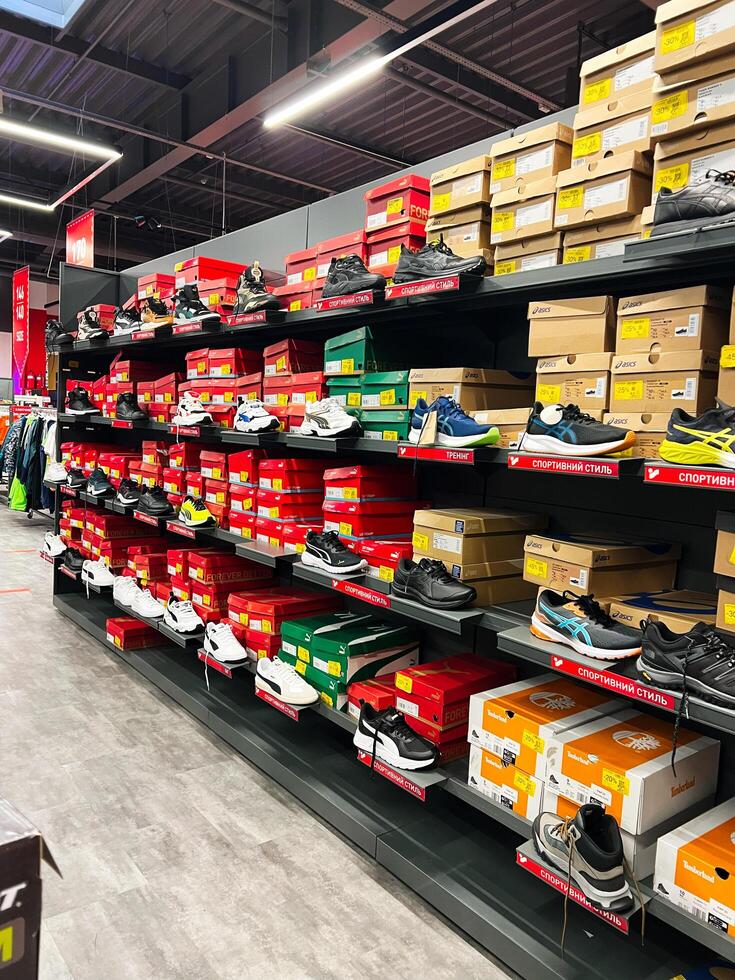 Kyiv, Ukraine - November 20, 2024 Variety of sneakers displayed in modern retail shoe store photo