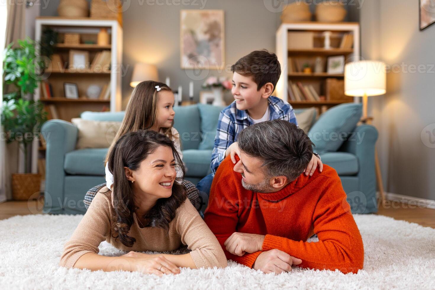 A family is sitting on the floor in a living room photo