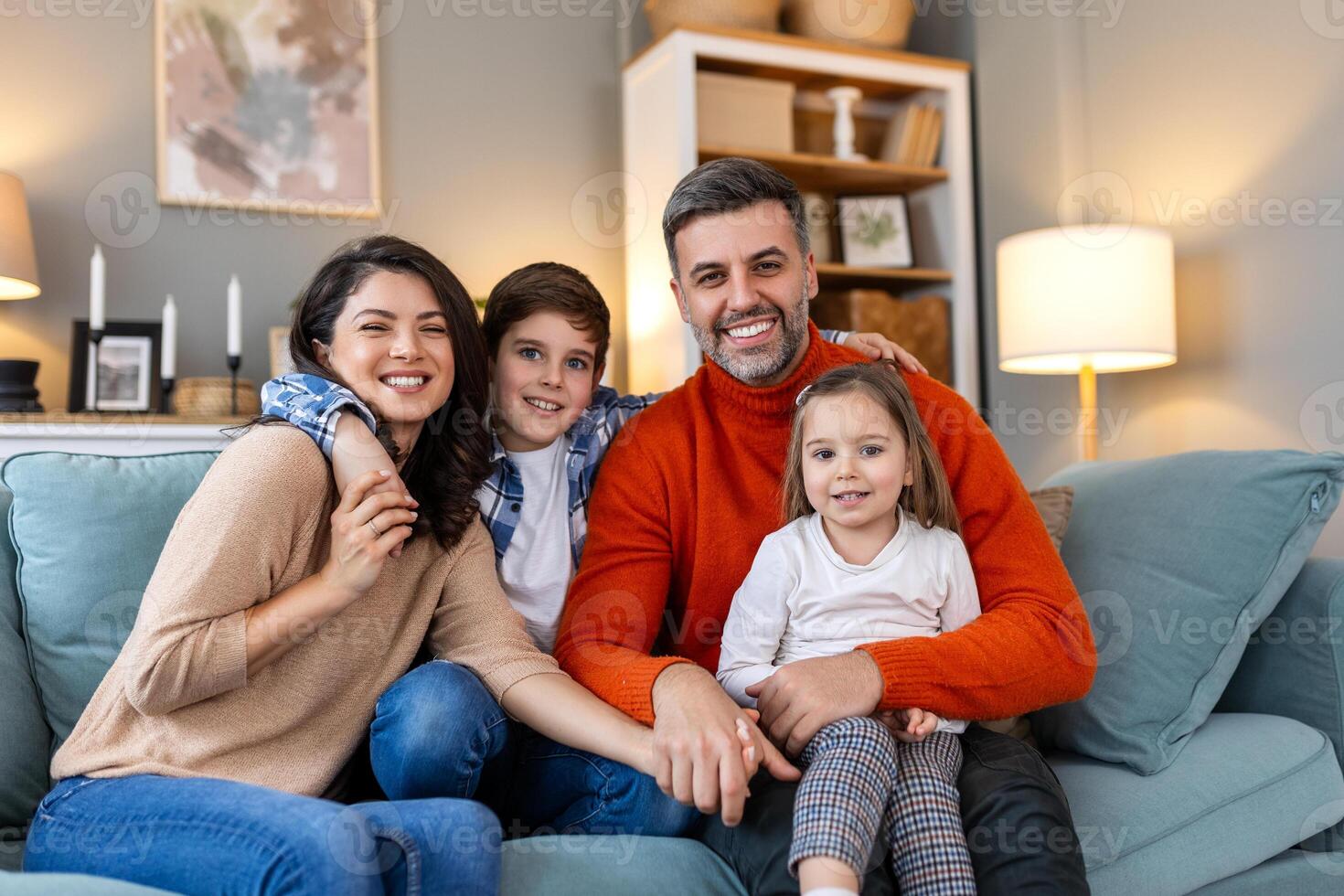 A family sitting on a couch in their living room photo