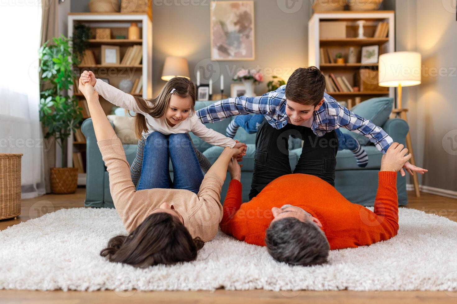 A family is playing on a rug in their living room photo
