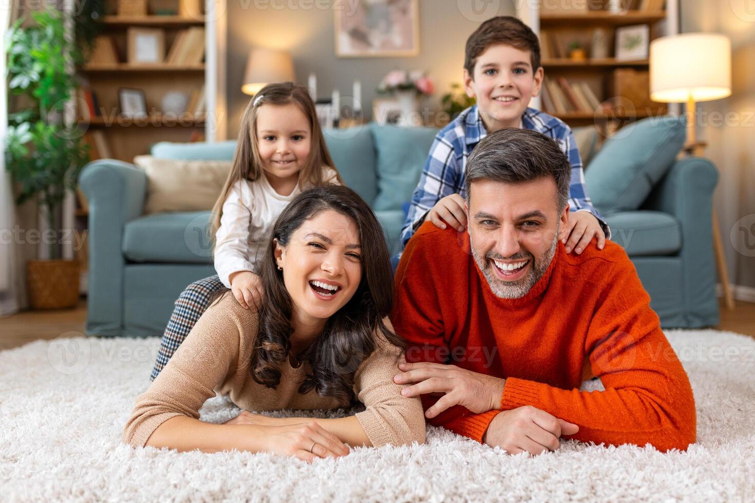 A family is lying on a rug in a living room photo