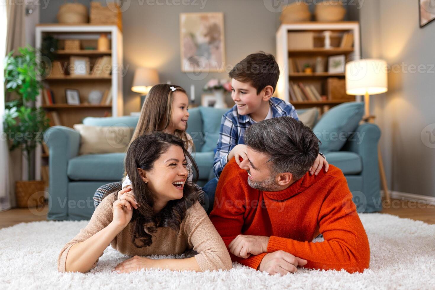 A family is sitting on the floor in a living room photo