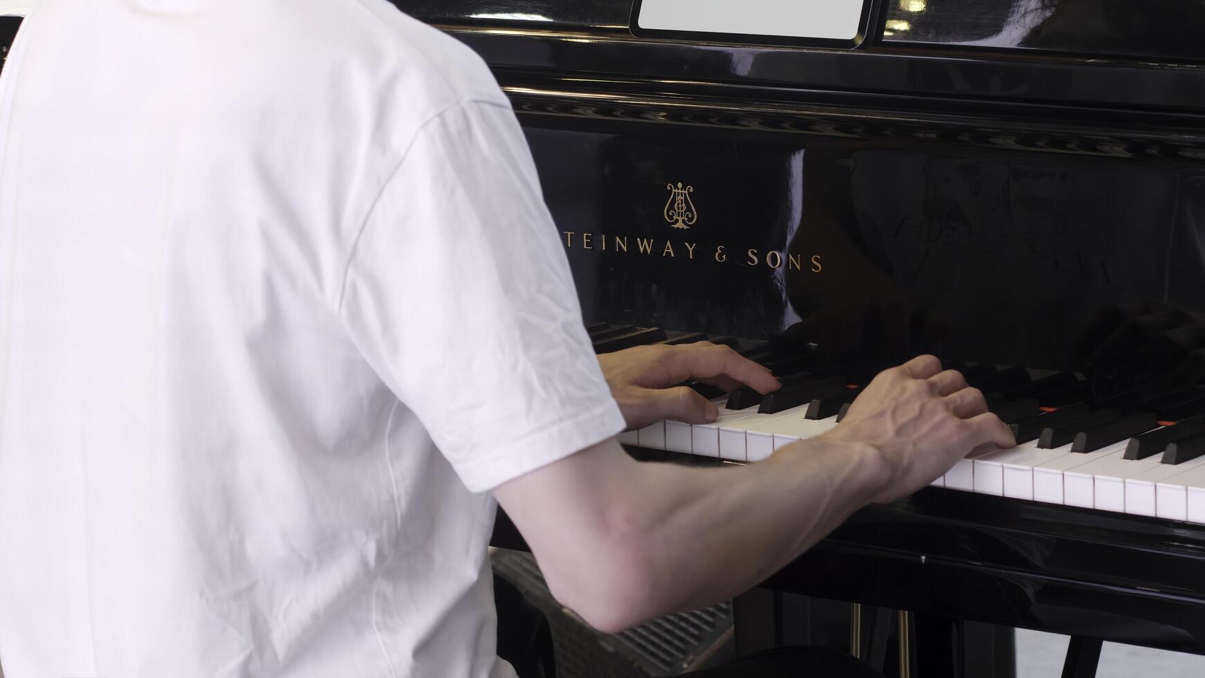 Georgia, Tbilisi - July 20, 2024. A talented person skillfully playing a beautiful piece on a majestic grand piano instrument. Clip photo