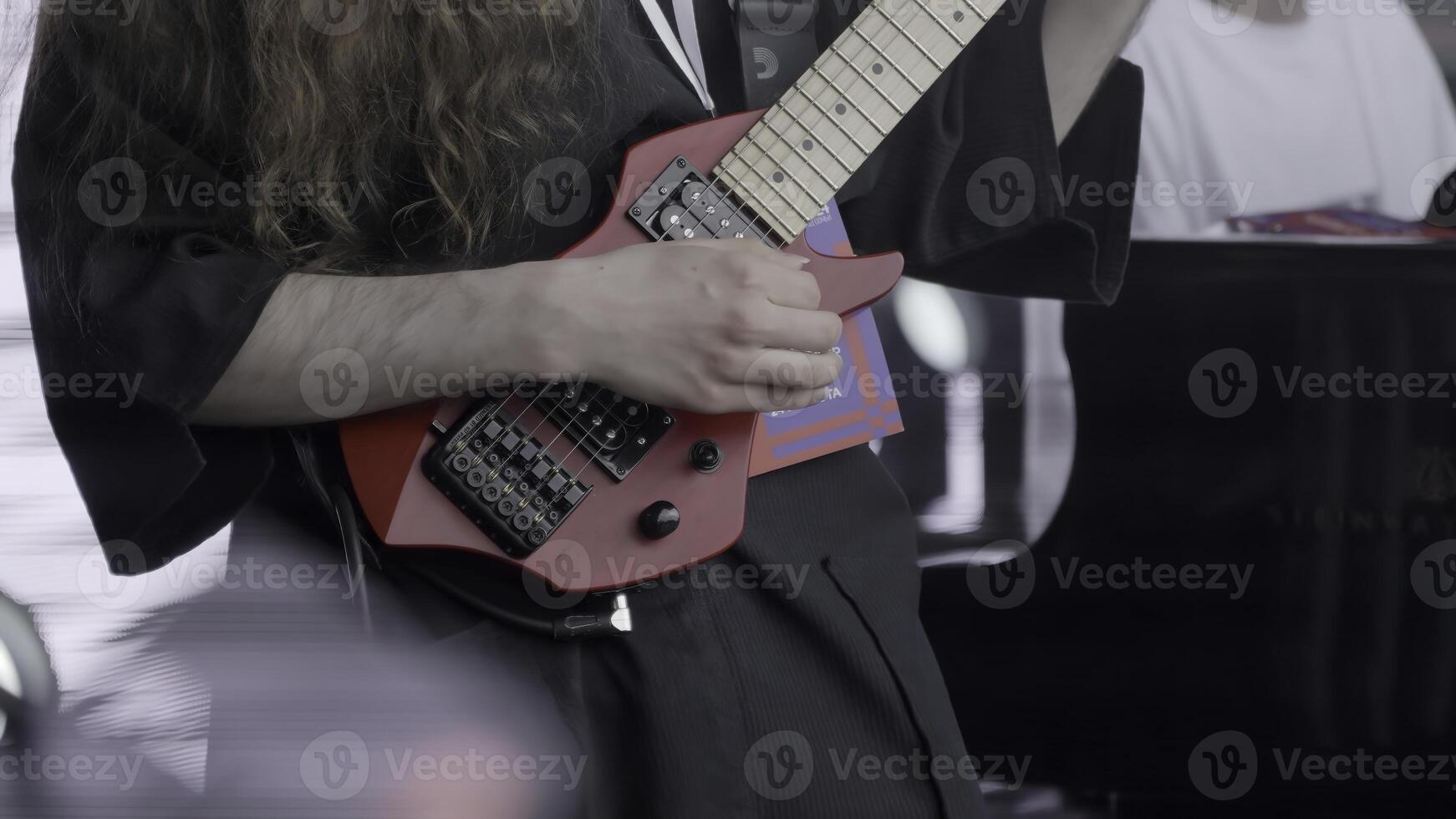 A Talented Musician Skillfully Performing Live with a Unique and Striking Red Guitar on Stage. Clip photo