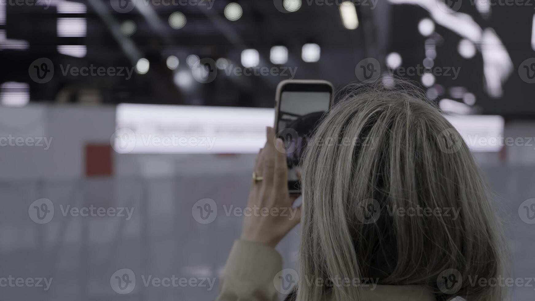 A woman deeply engaged in photographing a lively event. Clip. Capturing the Essence of the Moment at a Live Event for Everyone to Experience and Enjoy photo