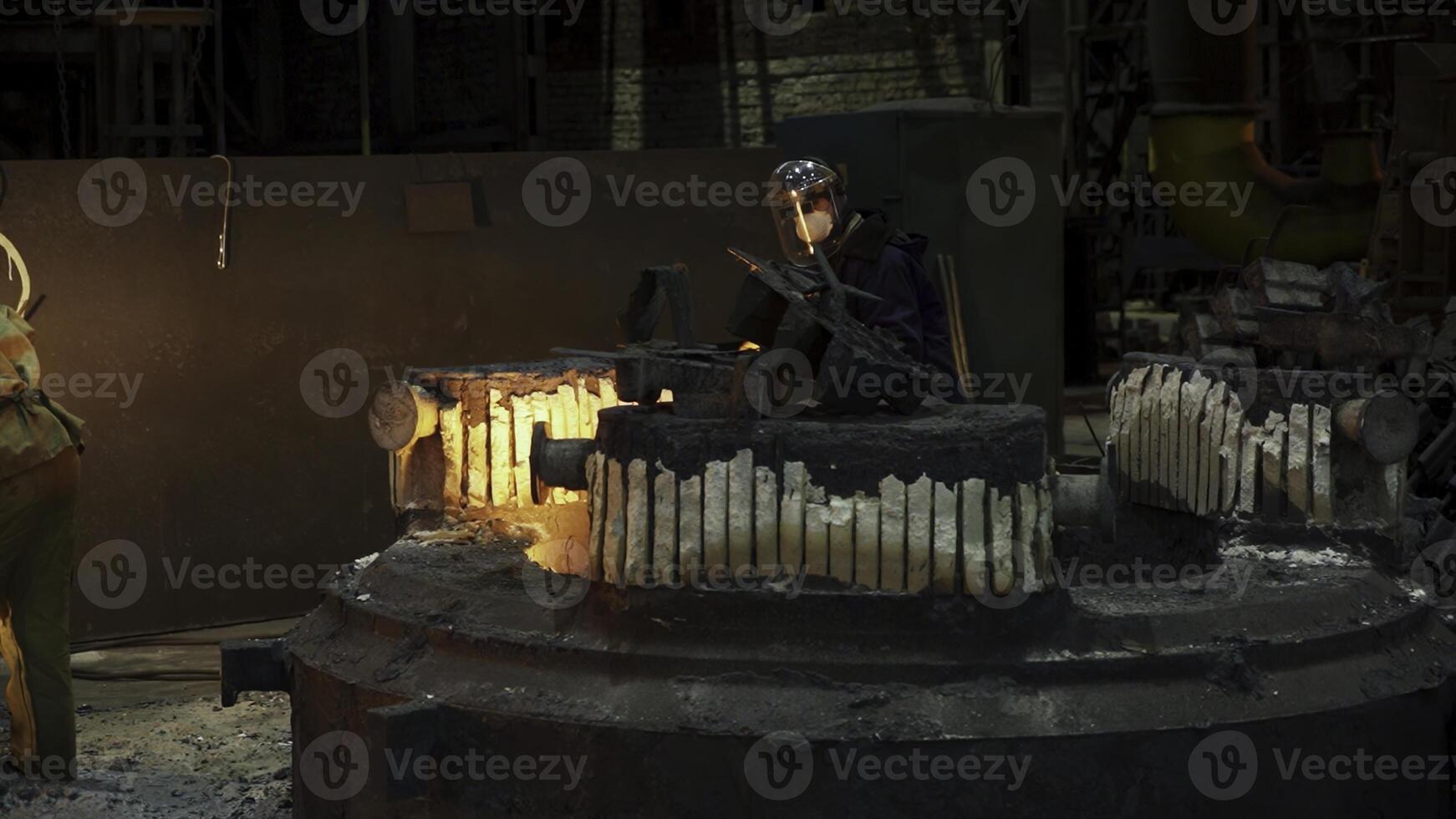 Workers in a foundry are engaged in the skillful casting of metal materials and components. Stock Clip photo