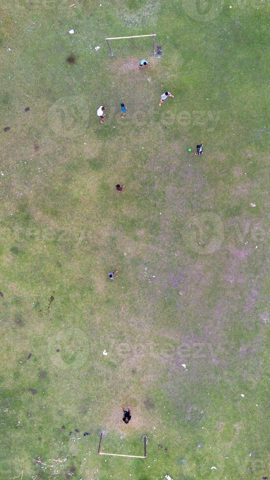 Aerial view of people playing soccer on green grass field in public park photo