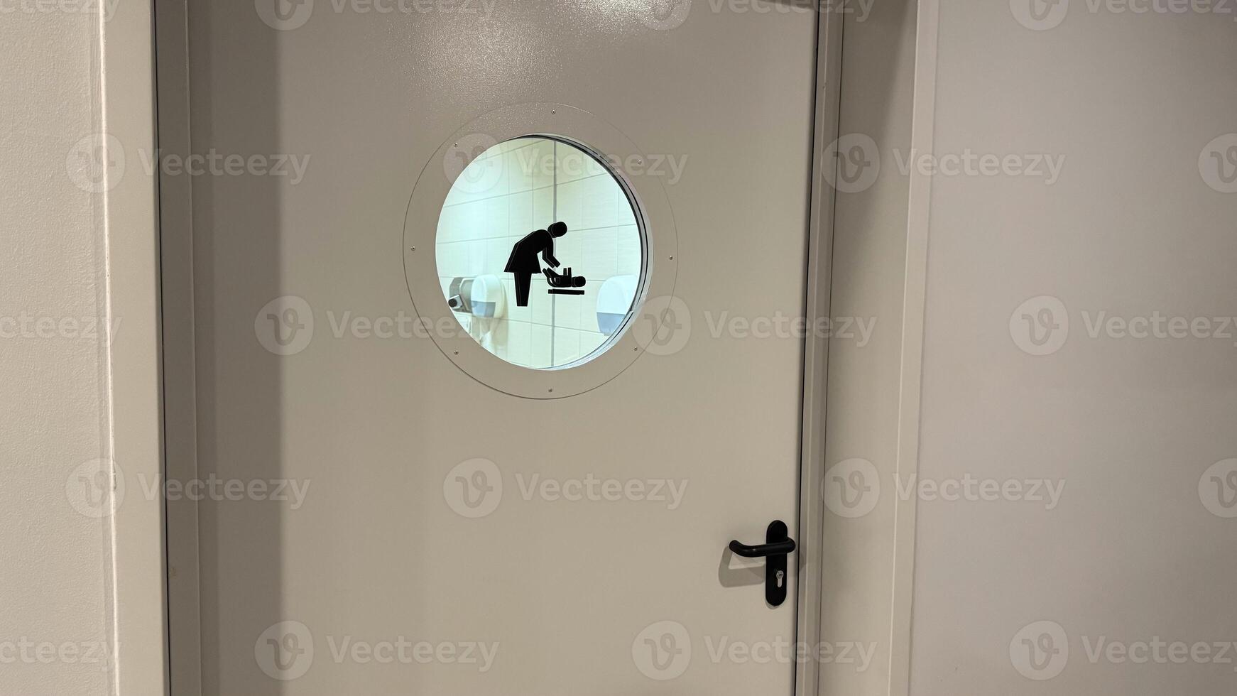 Door to baby changing room with symbol on glass window in public place, comfortable space with care for mothers with small children, entrance to room for changing baby diaper photo