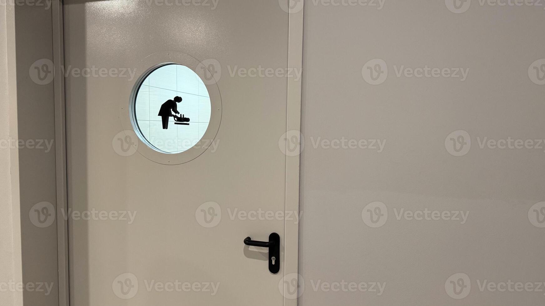Entrance door to room for caring for small child. Door to public toilet for changing baby diaper with mother and baby sign photo