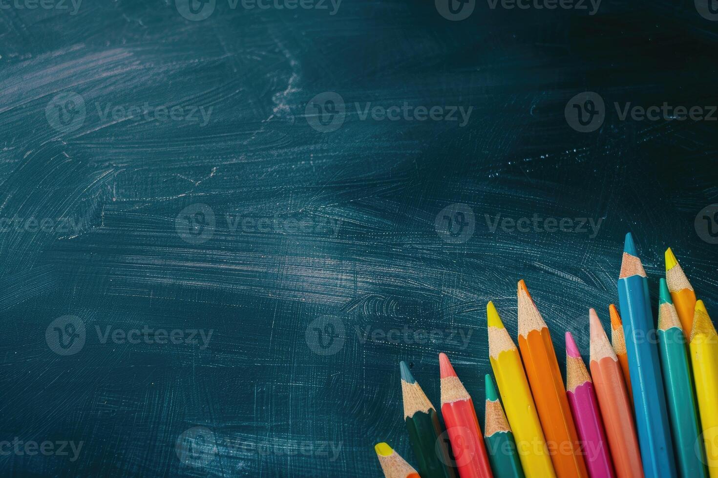 Colorful pencils on the black chalk board photo