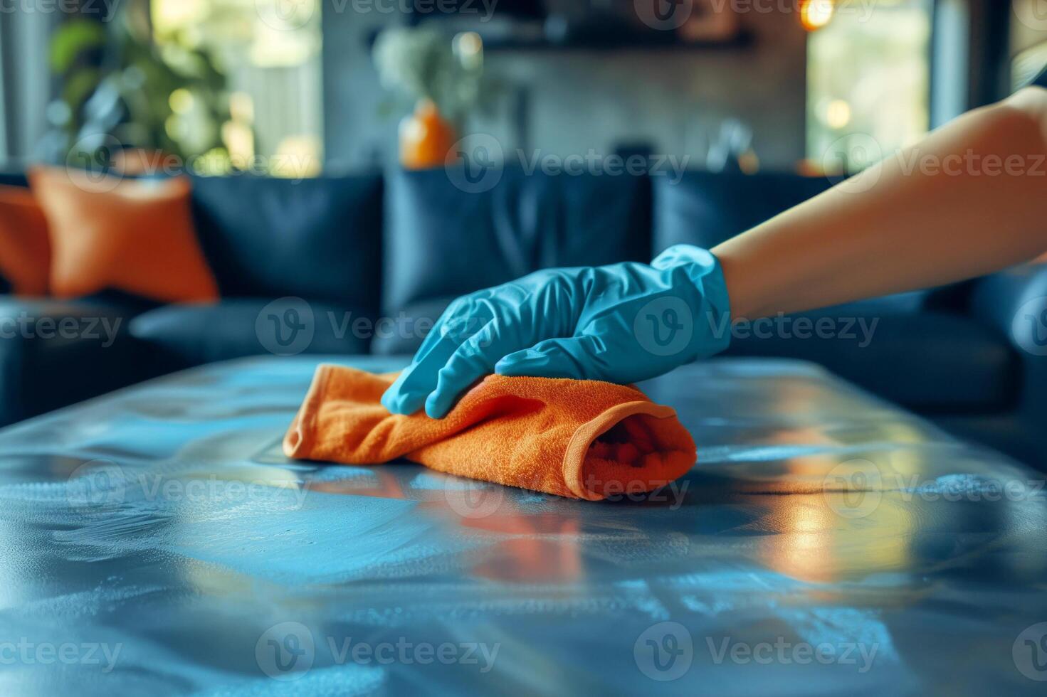 Female hand in gloves wiping dust from a table with a rag photo