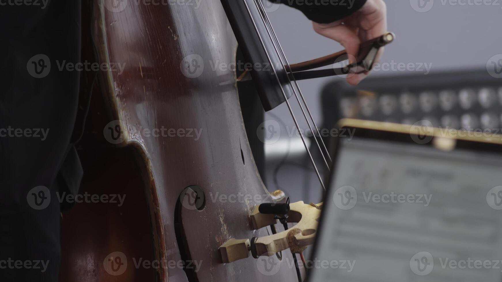 A talented musician skillfully playing the cello during an engaging performance on stage. Clip photo