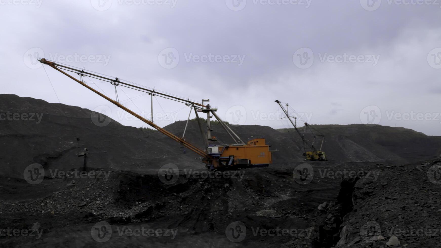 Heavy Machinery Utilized in Mining Operations Under Overcast and Cloudy Skies Conditions. Stock Clip photo