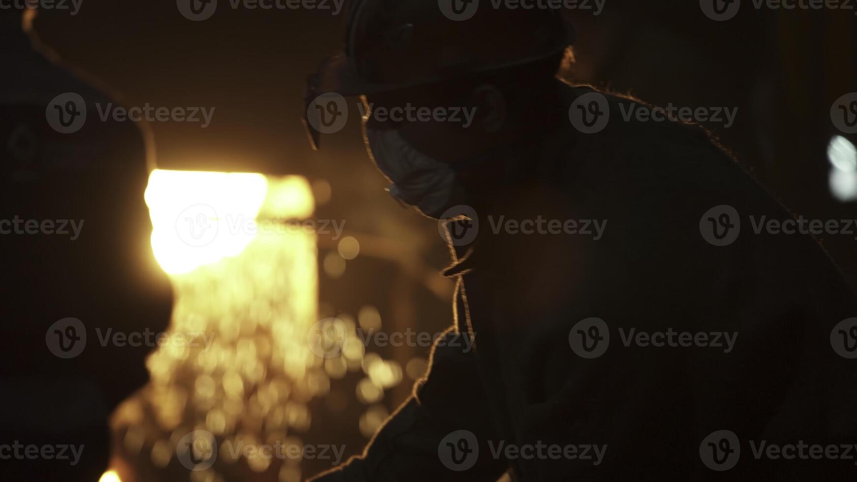An Industrial Worker Dressed in Protective Gear at a Metal Foundry Engaged in Vital Tasks. Stock Clip photo
