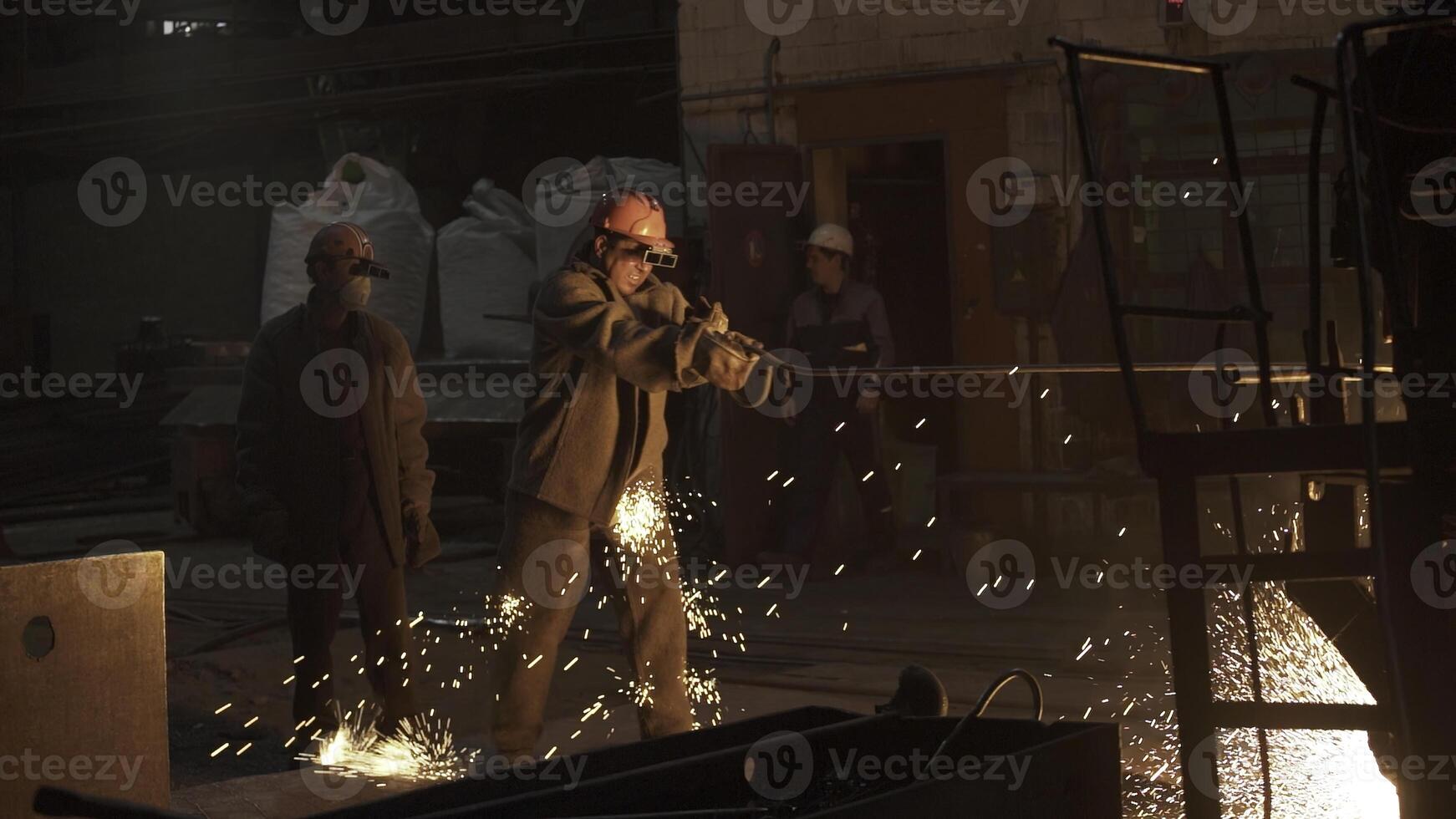 Dedicated workers are efficiently operating large machinery within an industrial setting. Stock Clip photo