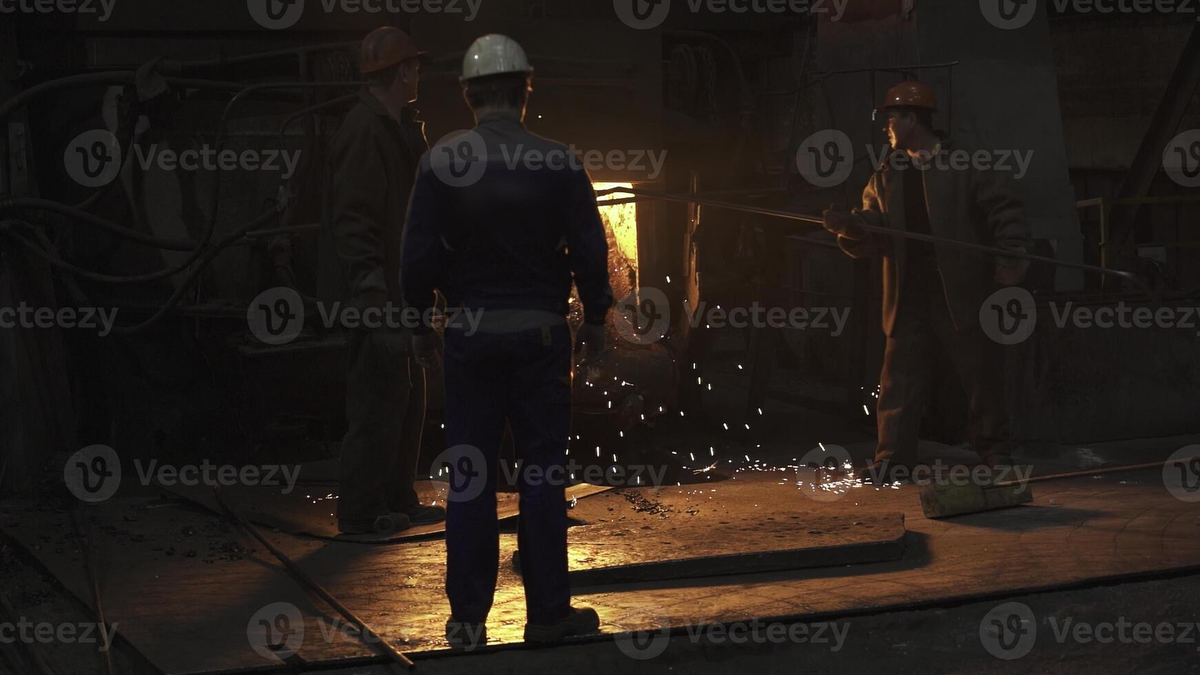 Workers in an Industrial Setting Handling Molten Metal with Expertise and Safety Measures in Place. Stock Clip photo