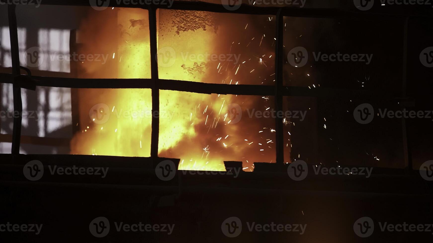 In an industrial setting, hot metal is poured with dazzling sparks, showing expertise and skill. Stock Clip photo