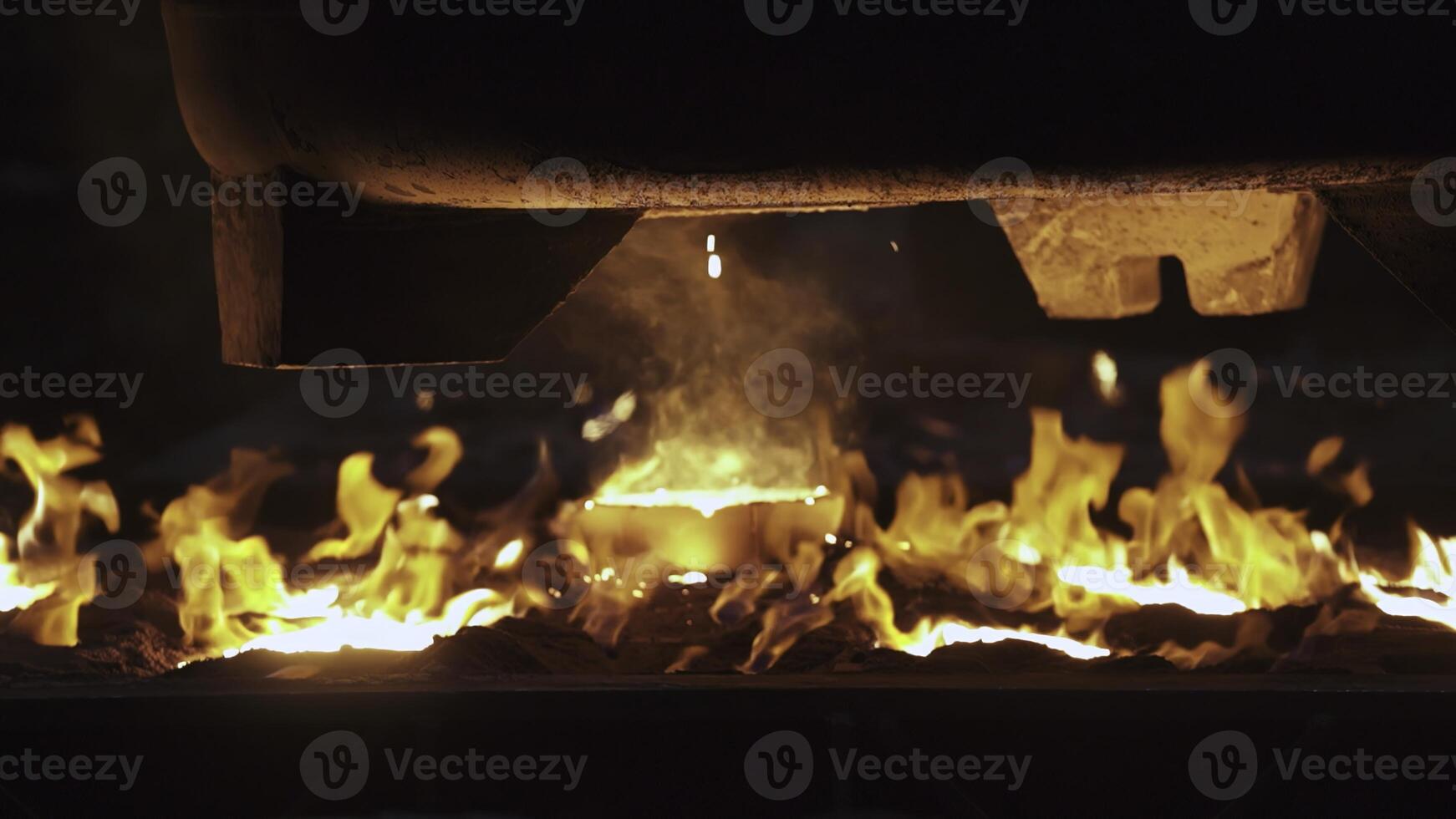 Brilliantly Glowing Flames Flickering Beneath a Metal Surface in the Dark Environment. Stock Clip photo