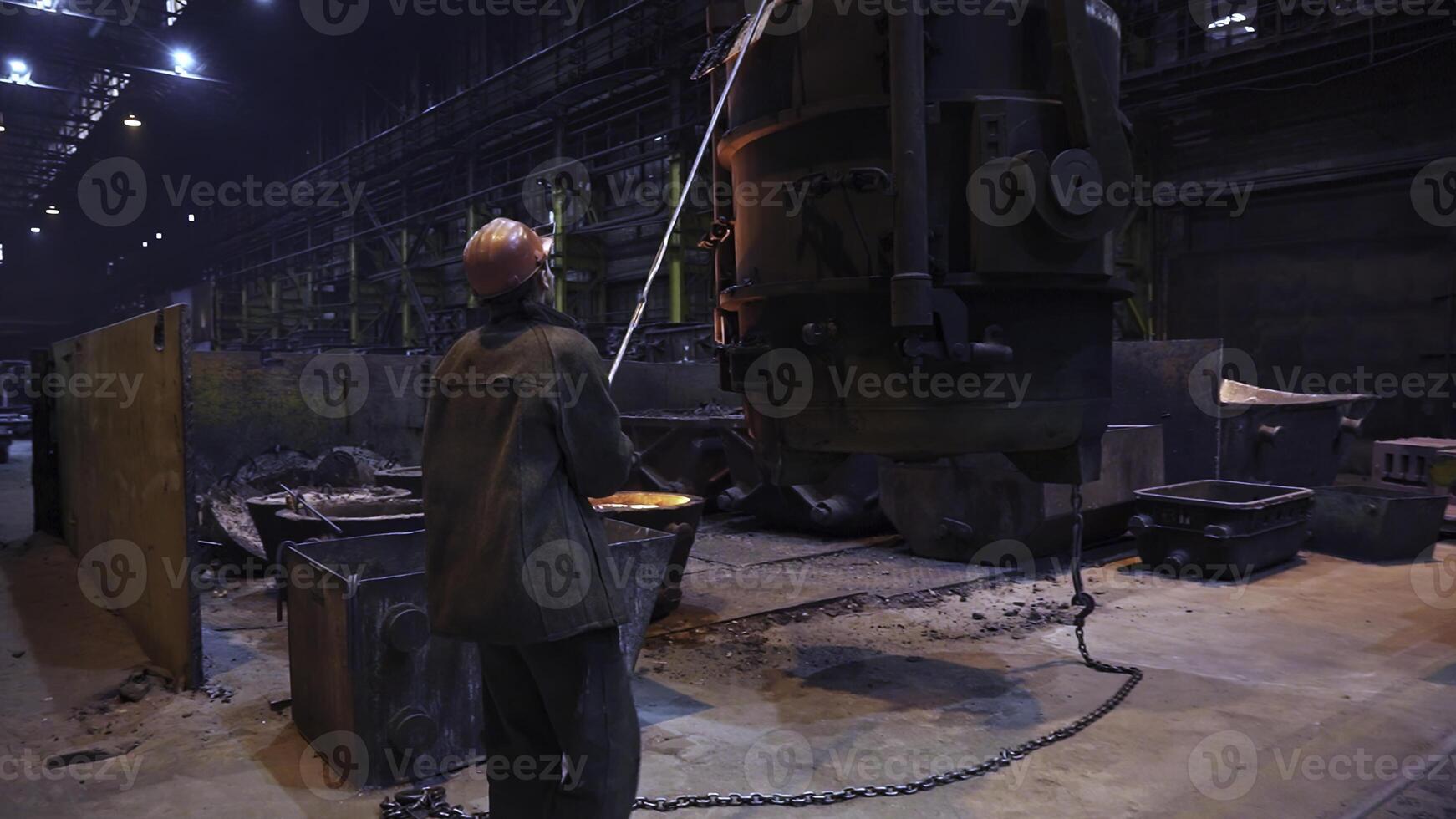 An Industrial Worker Concentrating on Operating Heavy Machinery Within a Factory Setting. Stock Clip photo