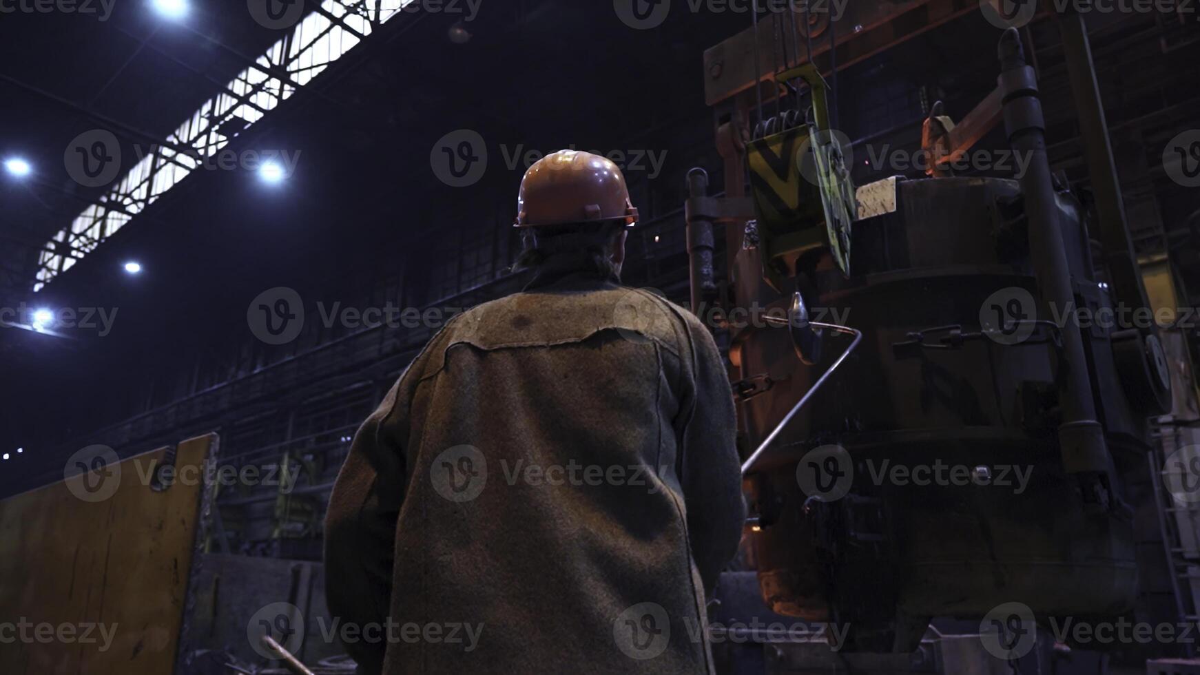 An Industrial Worker Concentrating on Operating Heavy Machinery Within a Factory Setting. Stock Clip photo
