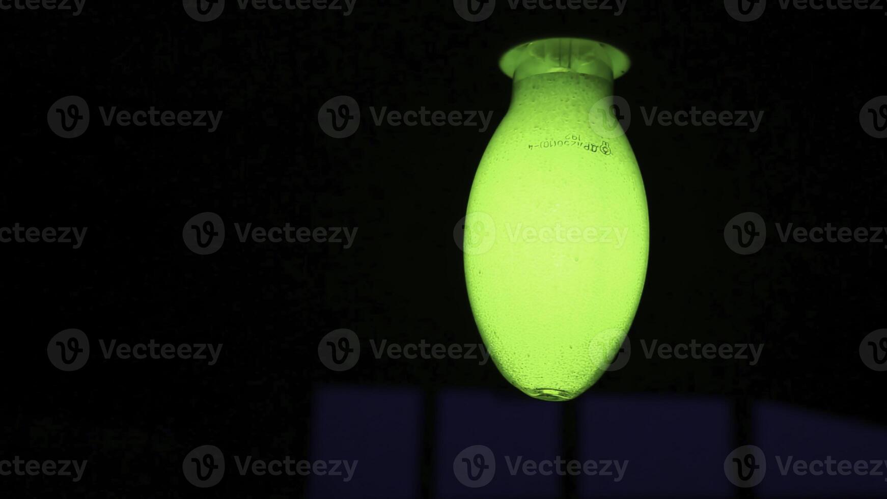A Glowing Green Light Fixture Set Against a Dark Background, Creating an Eye Catching Contrast. Stock Clip photo