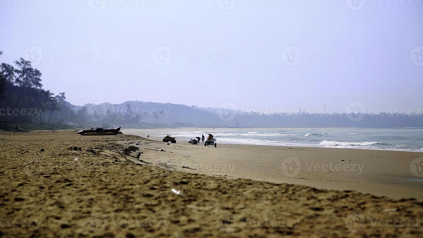 A Serene Beach Landscape featuring Gentle Waves lapping against the shore and Distant Hills beyond. Stock Clip photo