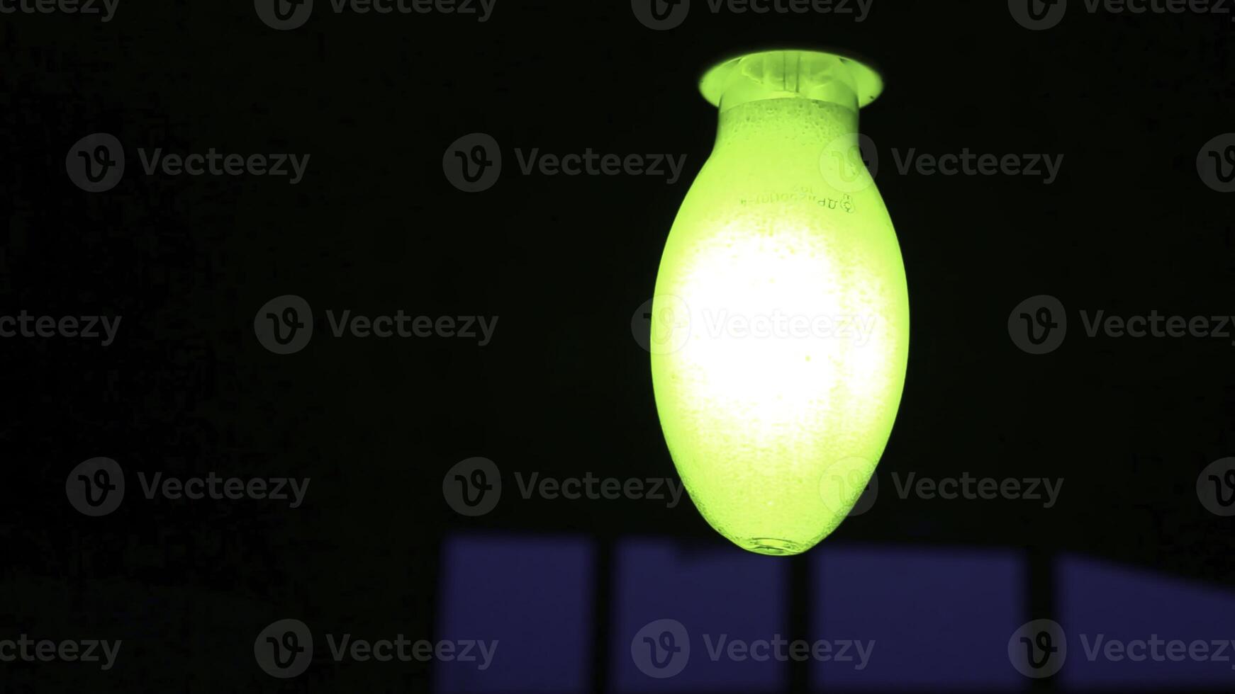 A Glowing Green Light Fixture Set Against a Dark Background, Creating an Eye Catching Contrast. Stock Clip photo