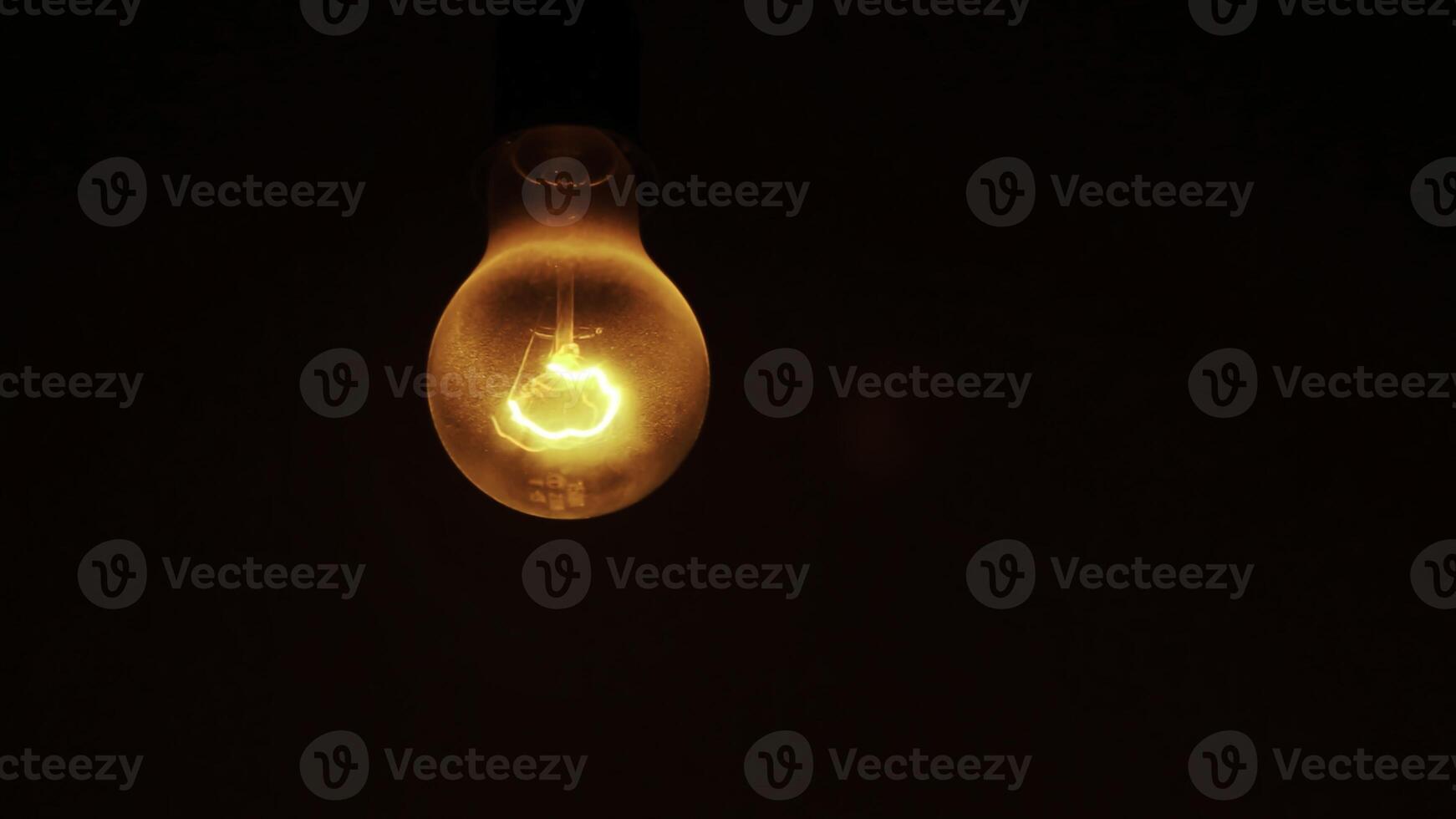 An Illuminated Light Bulb Set Against a Dark Background Creating a Striking Visual Contrast. Stock Clip photo