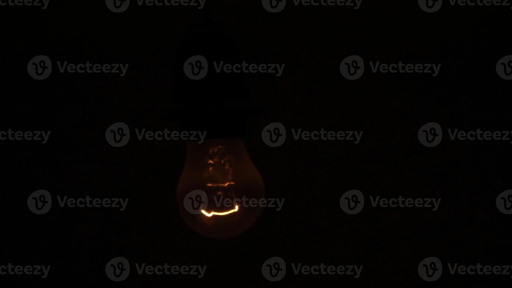A Glowing Red Light Bulb Brightly Illuminating a Dark Setting for an Intimate Atmosphere. Stock Clip photo