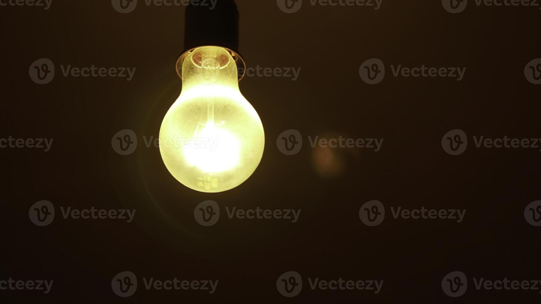 An Illuminated Light Bulb Set Against a Dark Background Creating a Striking Visual Contrast. Stock Clip photo