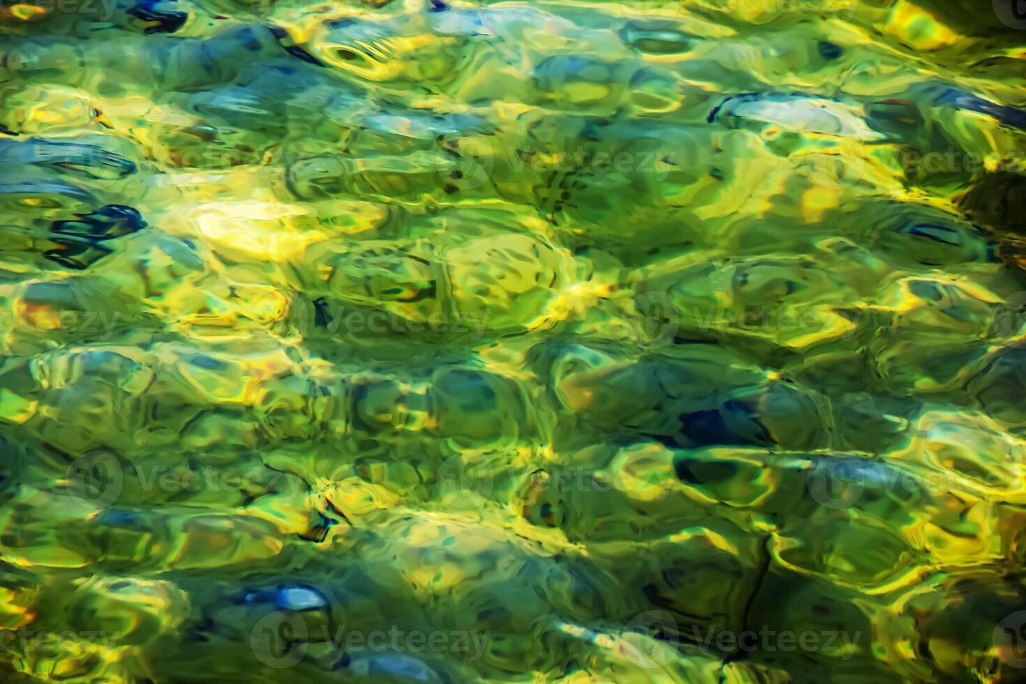 Background of the water of Lake Traunsee in the coastal area. Colorful texture of stones under water photo