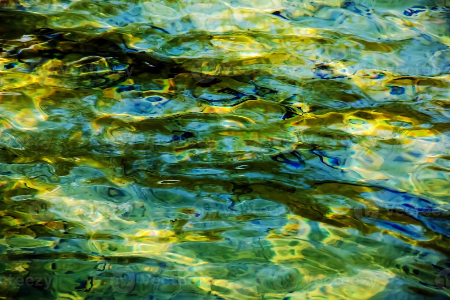 Background of the water of Lake Traunsee in the coastal area. Colorful texture of stones under water photo