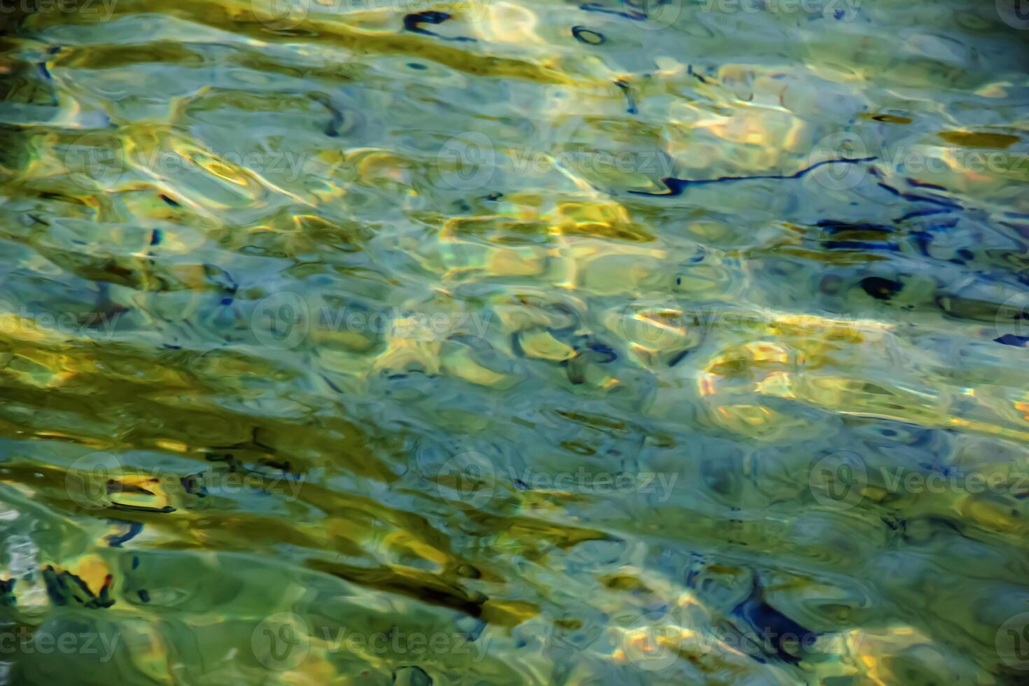 Background of the water of Lake Traunsee in the coastal area. Colorful texture of stones under water photo