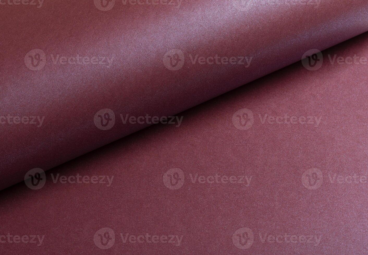 Metallic burgundy paper background with a smooth, shimmering surface and elegant folds. Featuring a photo