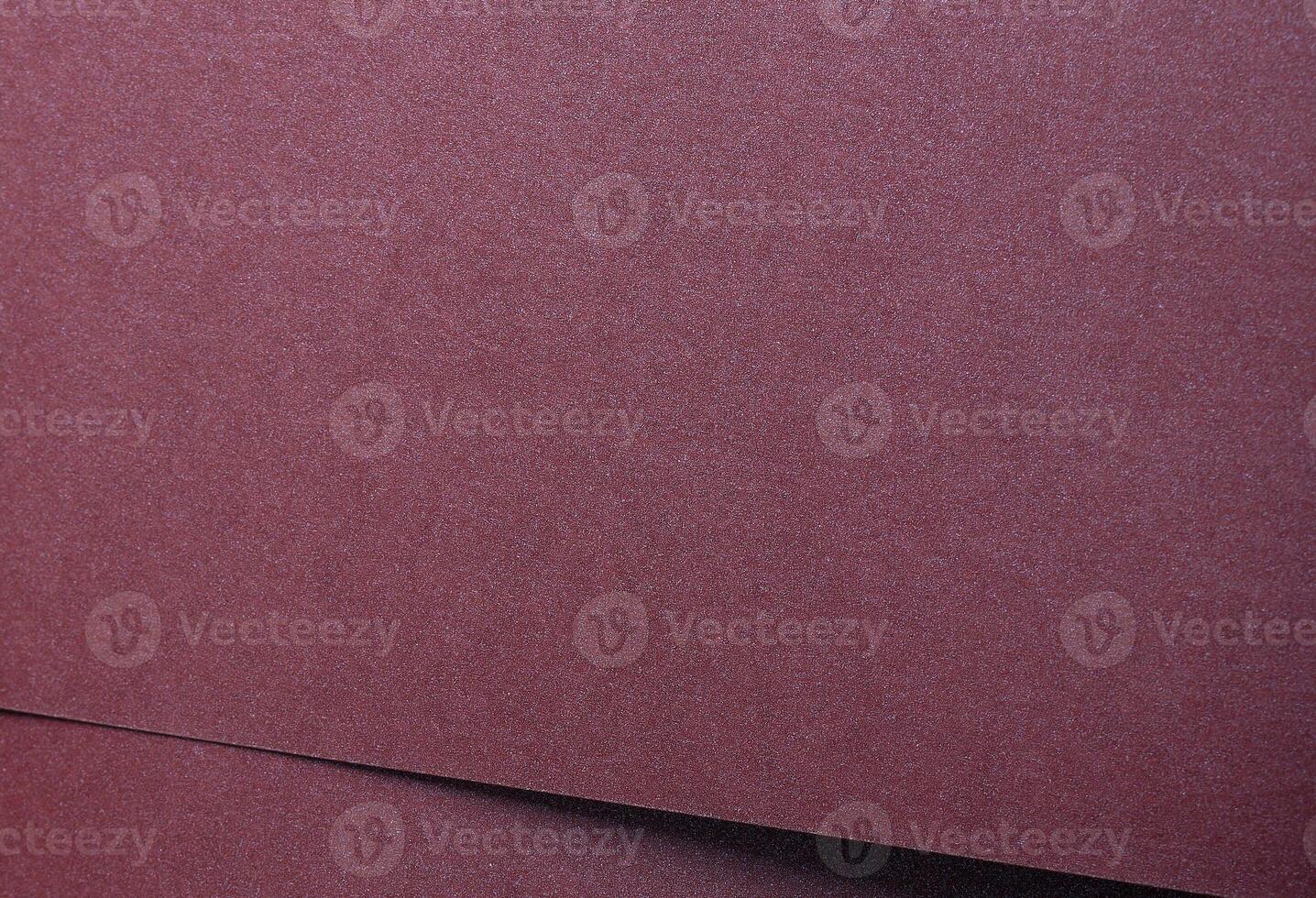 Metallic burgundy paper background with smooth, shimmering layers and subtle folds. Featuring deep, photo
