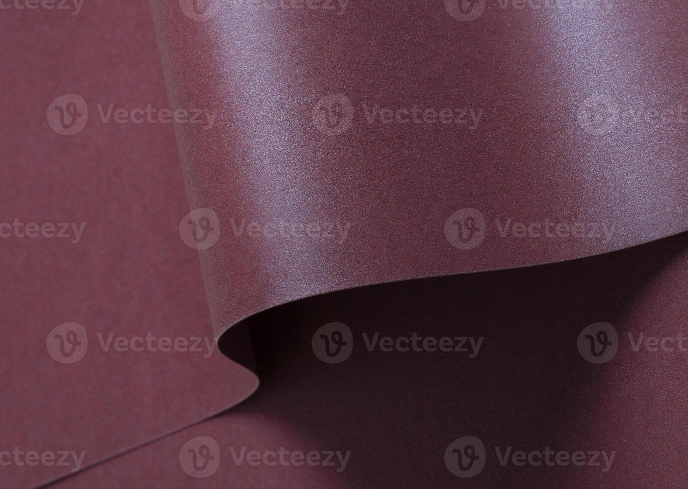 Burgundy metallic paper background with a shimmering, sleek surface and soft folds. Featuring a rich photo
