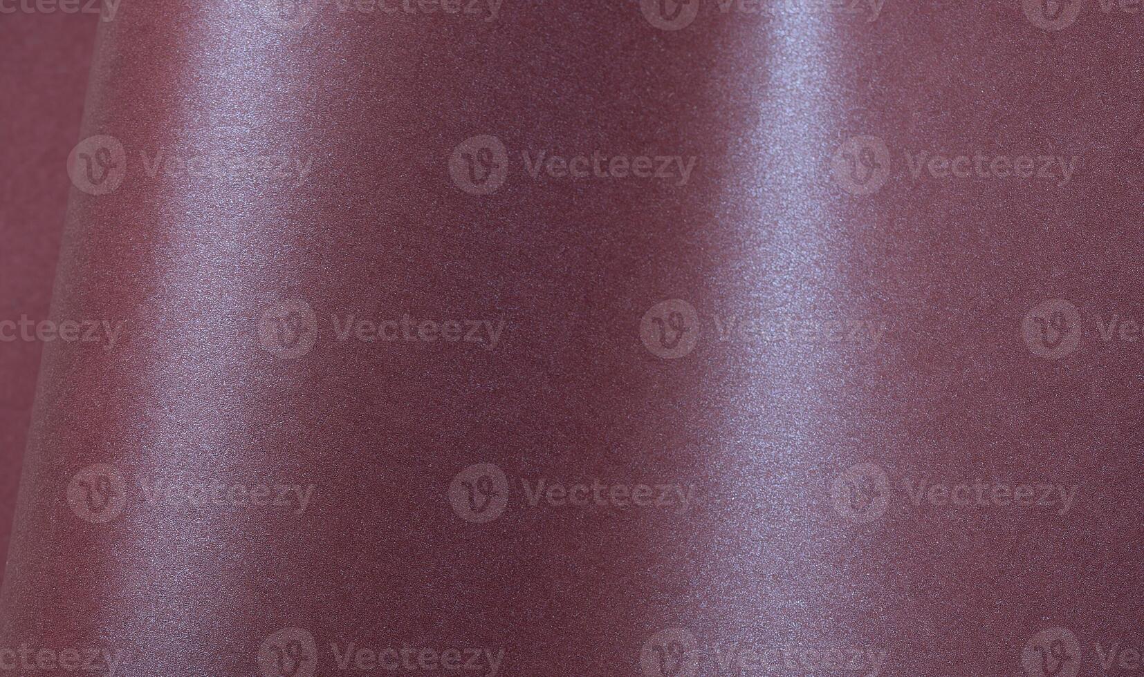 Metallic burgundy paper background with a shimmering, glossy surface and soft folds. Featuring a photo