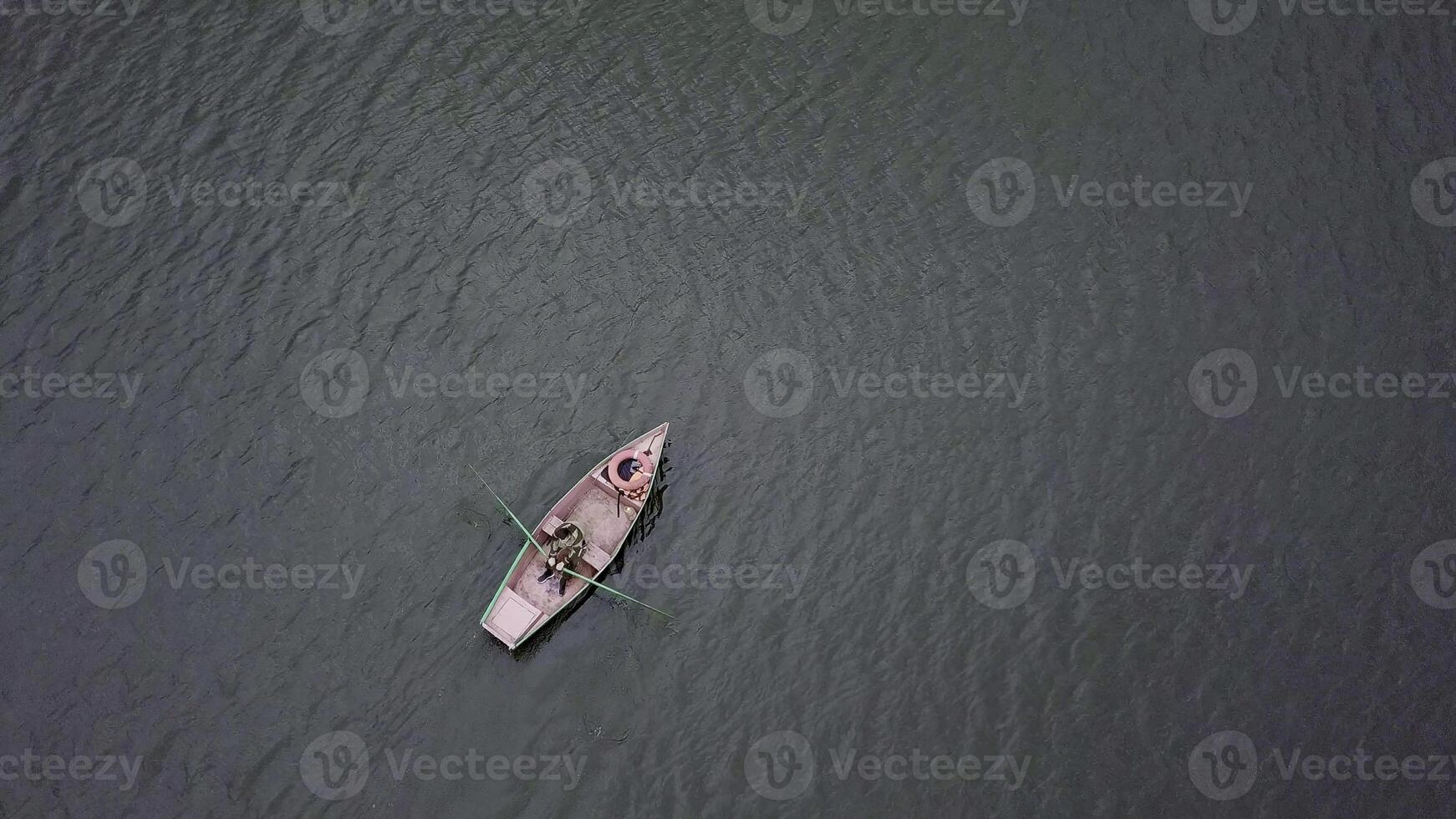 A peaceful and serene rowboat gently floats on calm and tranquil waters, embodying relaxation. Stock Clip photo